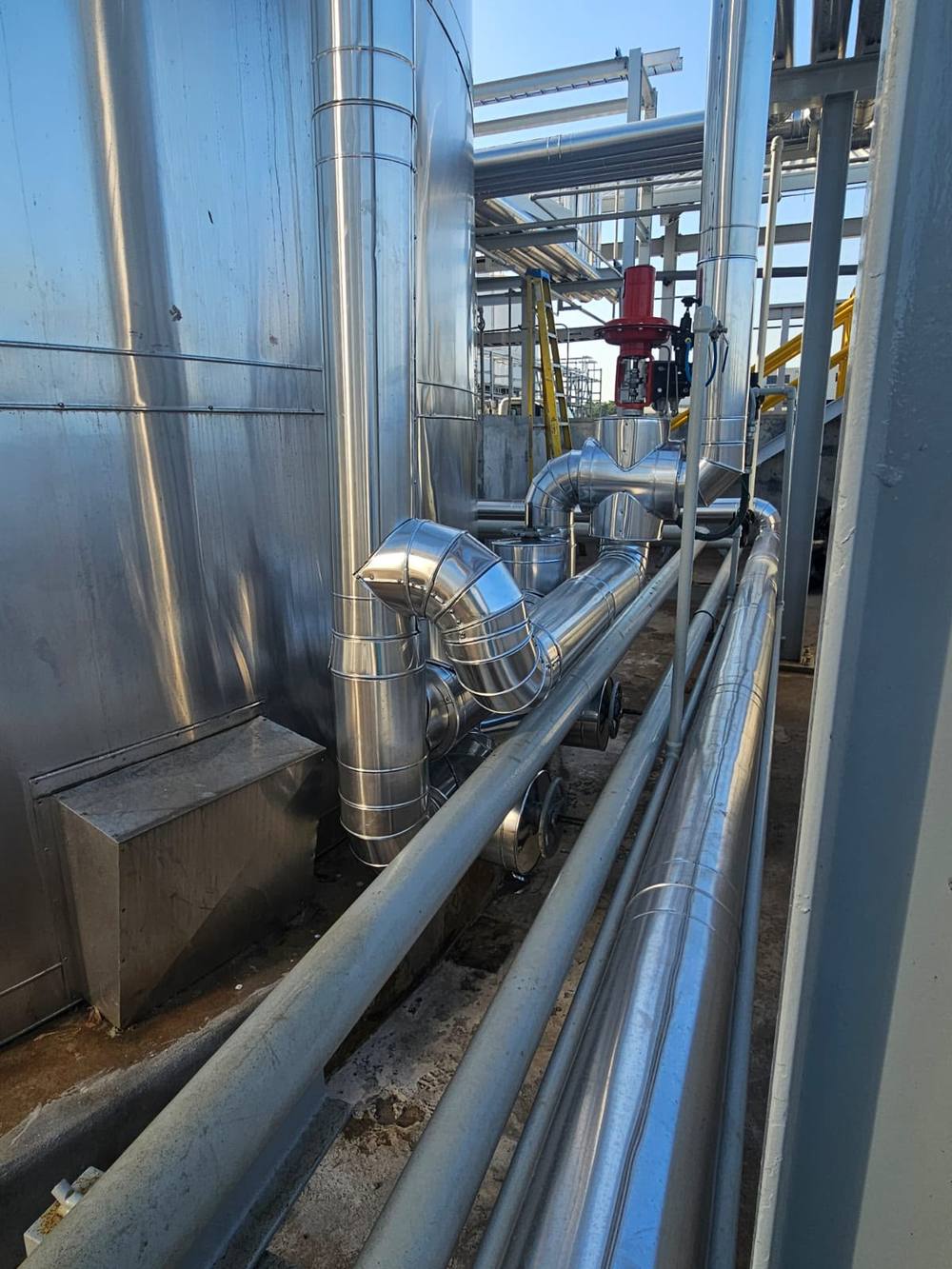 Red de tuberías industriales con aislamiento térmico y forro metálico