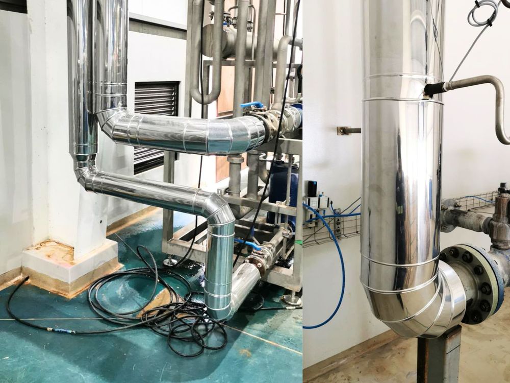 Tuberías de proceso con aislamiento térmico y revestimiento metálico en planta industrial